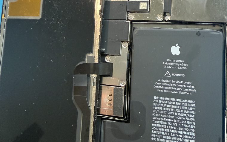 iPhone opened to show its battery during a battery replacement