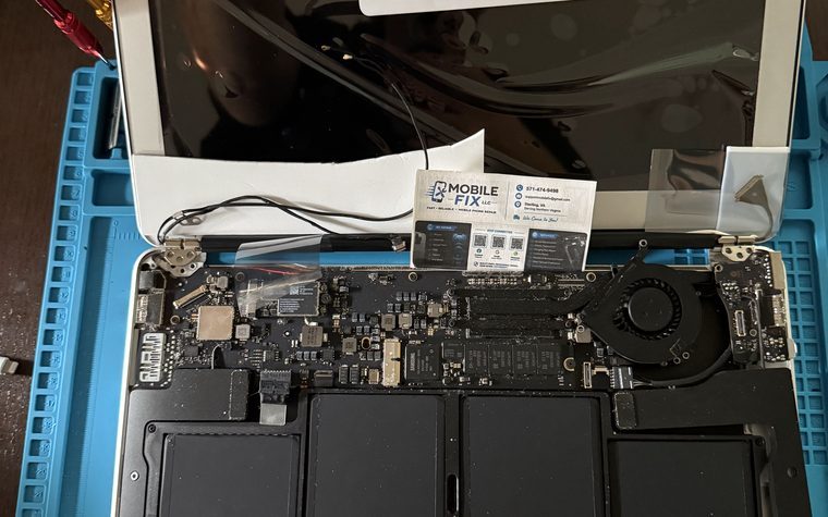 MacBook Air opened for repair, showing its logic board and battery
